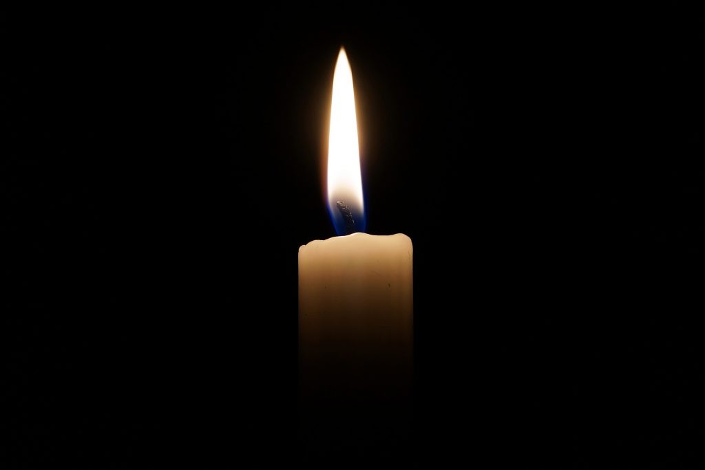 A lit candle in the dark.