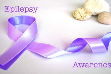 Epilepsy Awareness overlaid a flowing purple ribbon near a set of stable rocks.